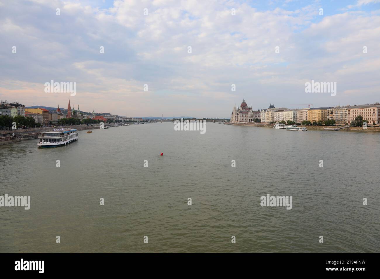 Ampio panorama del fiume Danubio con una barca per trasportare i turisti nella città di Budapest, capitale dell'Ungheria Foto Stock