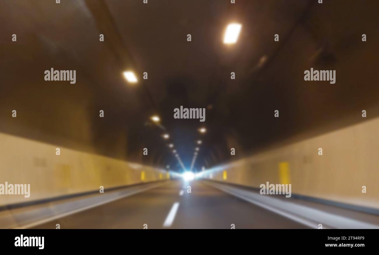 tunnel stradale asfaltato intenzionalmente senza auto e si vede la luce in lontananza, ideale come concetto di speranza Foto Stock