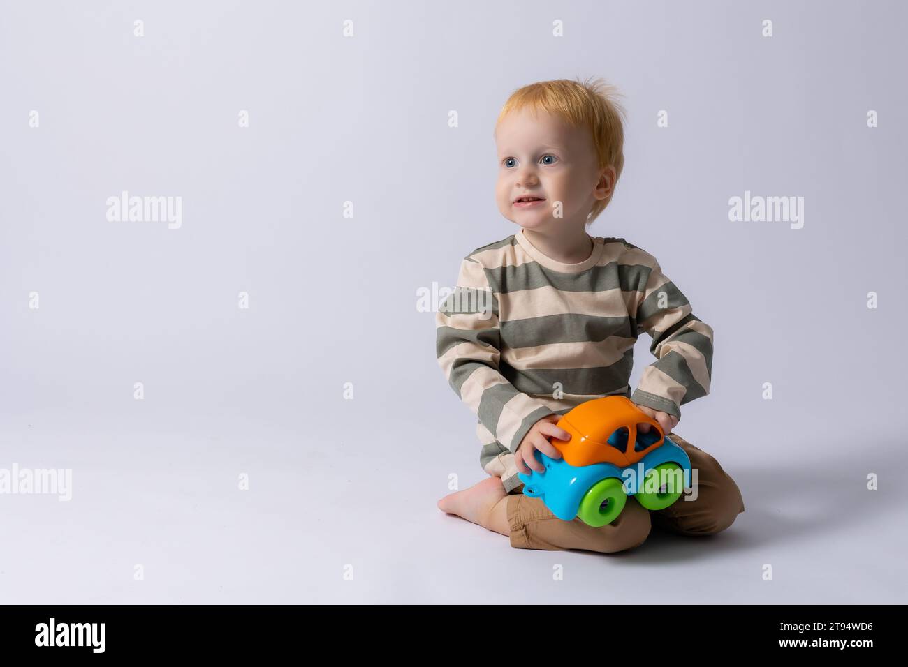 bambino che gioca con una macchina da scrivere su sfondo bianco Foto Stock