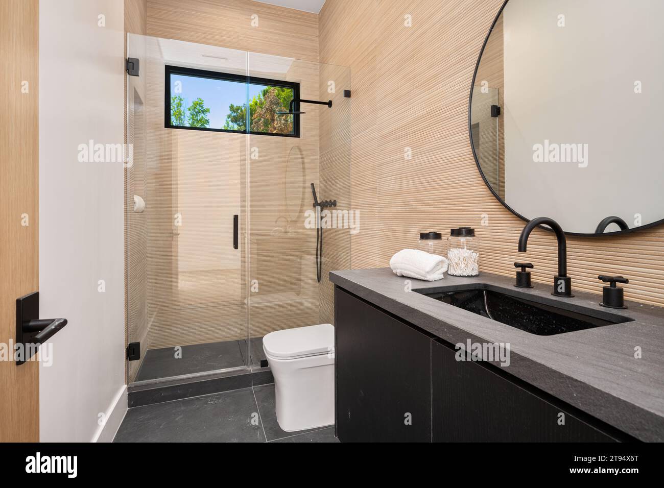 Questo bagno luminoso e arioso è pronto per essere utilizzato e apprezzato, con una doccia moderna e superfici pulite Foto Stock