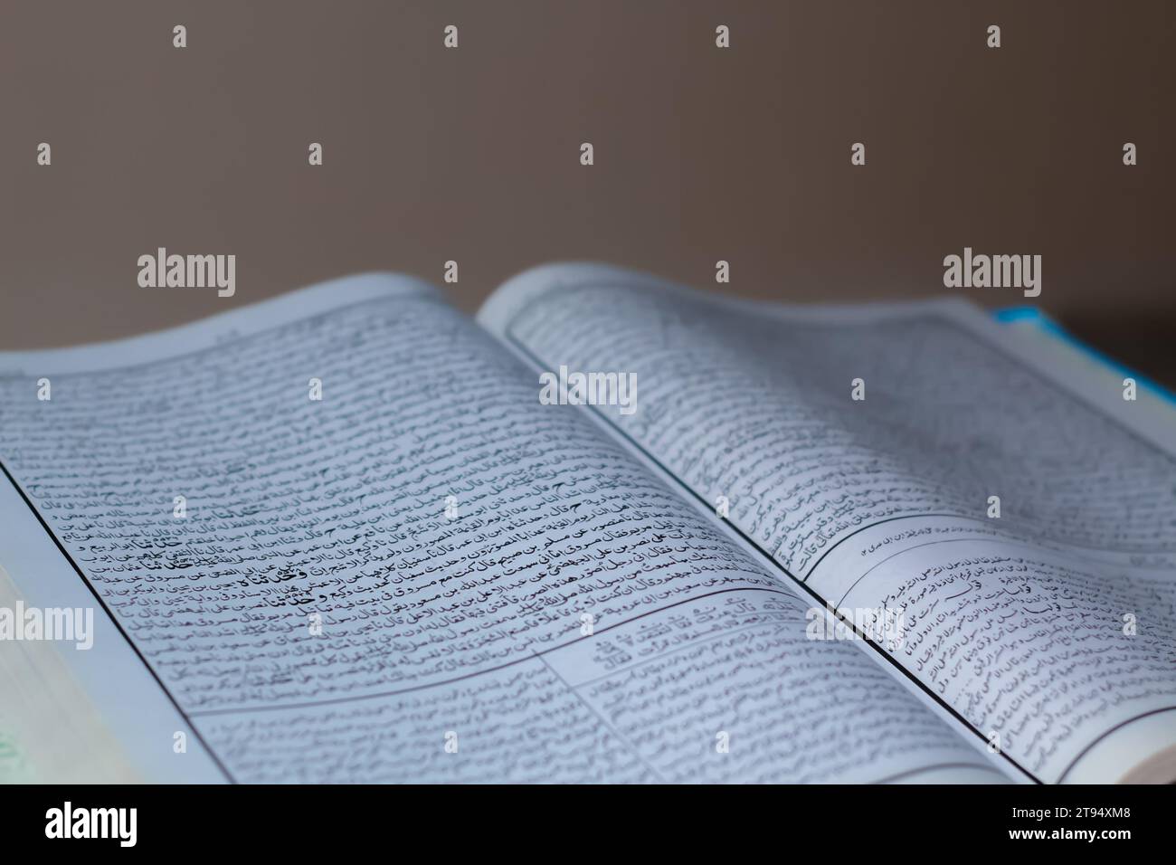 Libro hadith aperto musulmano Sahih che è collocato sul tavolo su sfondo scuro Foto Stock