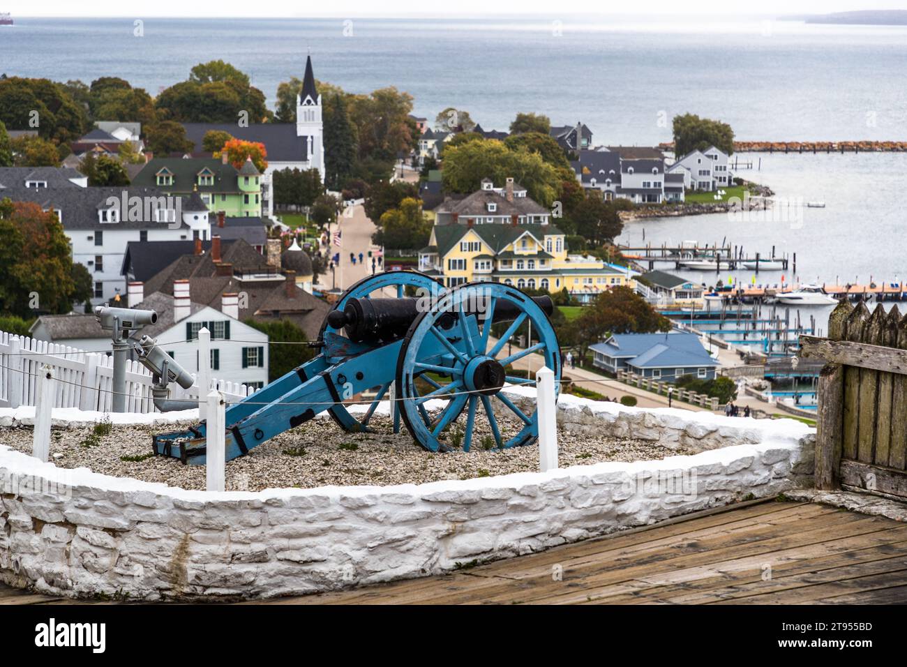 Un posto di cannoniera con un vecchio cannone si trova sulle mura di Fort Mackinac, che si affaccia sulla città e sul porto di Mackinac Island. I britannici fondarono il forte nel 1780. Il cannone viene ancora sparato quotidianamente per i saluti. Mackinac Island, Michigan, Stati Uniti. Foto Stock