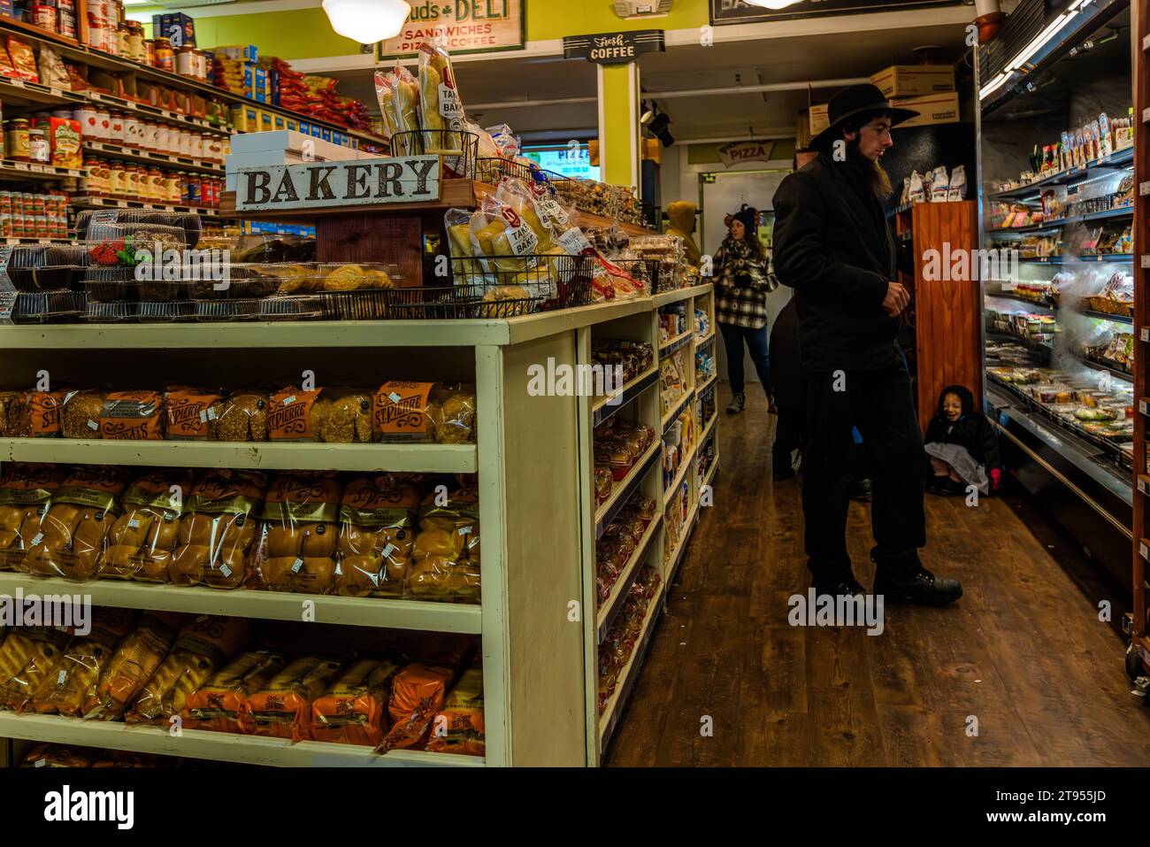Gli Amish fanno shopping al Doud's Market, il più antico negozio di alimentari d'America. Il negozio ha aperto a Mackinac Island nel 1884. Gli Amish si sentono come a casa sull'isola senza auto, che sembra essere caduta fuori dal tempo, proprio come lo stile di vita Amish. Gli Amish tradizionali e originali sono popolari sull'isola di Mackinac a causa della loro abilità artigianale, ad esempio nella costruzione e riparazione di carrozze. Con i loro abiti, si distinguono difficilmente nel Doud's Market, il più antico negozio di alimentari d'America. Mackinac Island, Michigan, Stati Uniti Foto Stock
