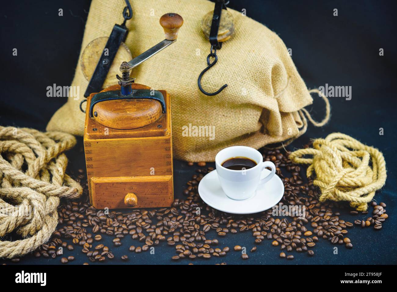 macinacaffè e tazza, chicchi di caffè, corda e sacco Foto Stock