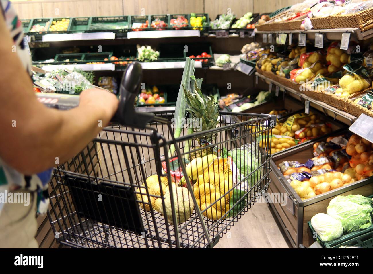 donna con carrello in un supermaket, frutta e verdura Foto Stock