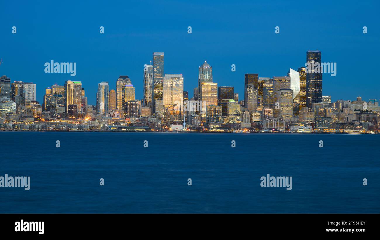 Seattle - 20 novembre 2023; cielo e acqua blu serali con il centro di Seattle illuminato dalle luci degli edifici Foto Stock