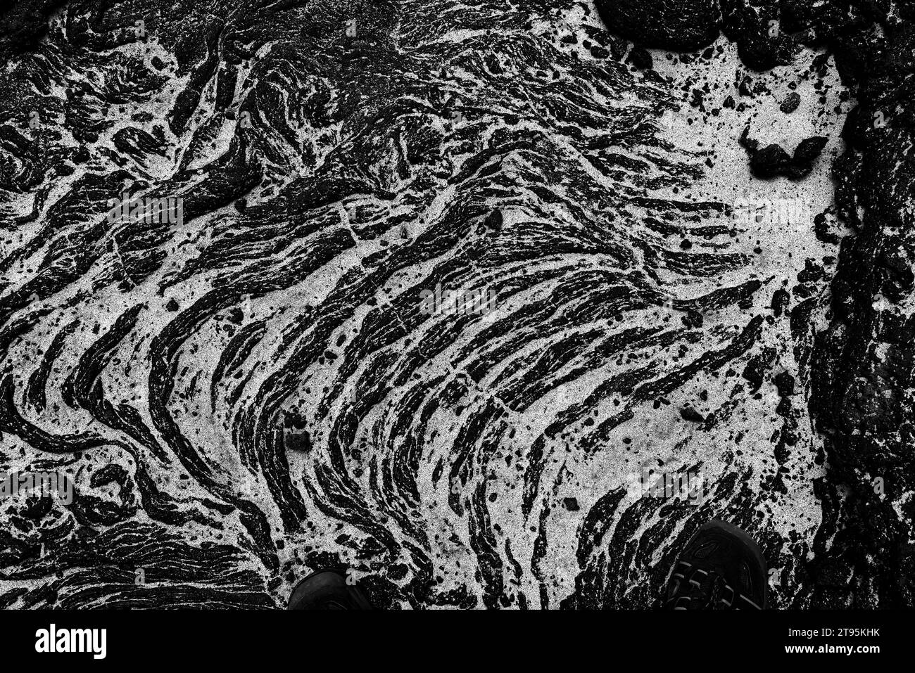 Background: La risorsa grafica della natura. Una scena monocromatica di una formazione di lava vulcanica nera con luci di sabbia bianca sull'isola di Santiago Foto Stock