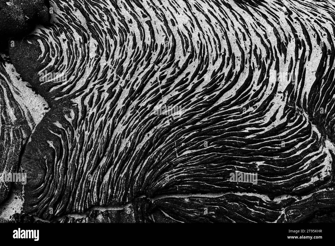 Background: La risorsa grafica della natura. Una scena monocromatica di una formazione di lava vulcanica nera con luci di sabbia bianca sull'isola di Santiago Foto Stock