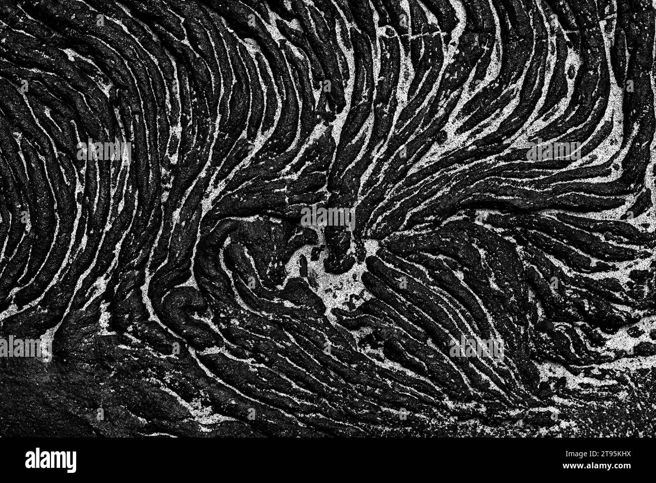 Background: La risorsa grafica della natura. Una scena monocromatica di una formazione di lava vulcanica nera con luci di sabbia bianca sull'isola di Santiago Foto Stock