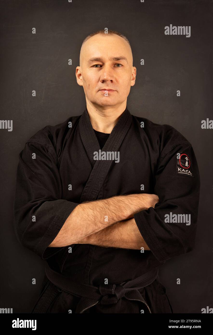 Ritratto del maestro aikido sensei con cintura sensei nera in kimono taekwondo su sfondo nero. Tradizionale samurai hakama kimono. Stile di vita sano Foto Stock