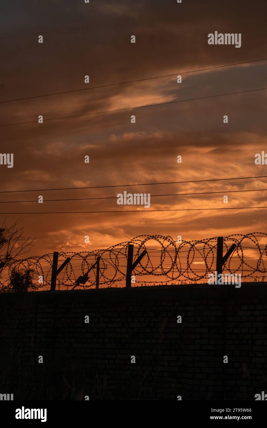 Le pareti e la rete metallica protettiva sotto il sole che tramonta Foto Stock