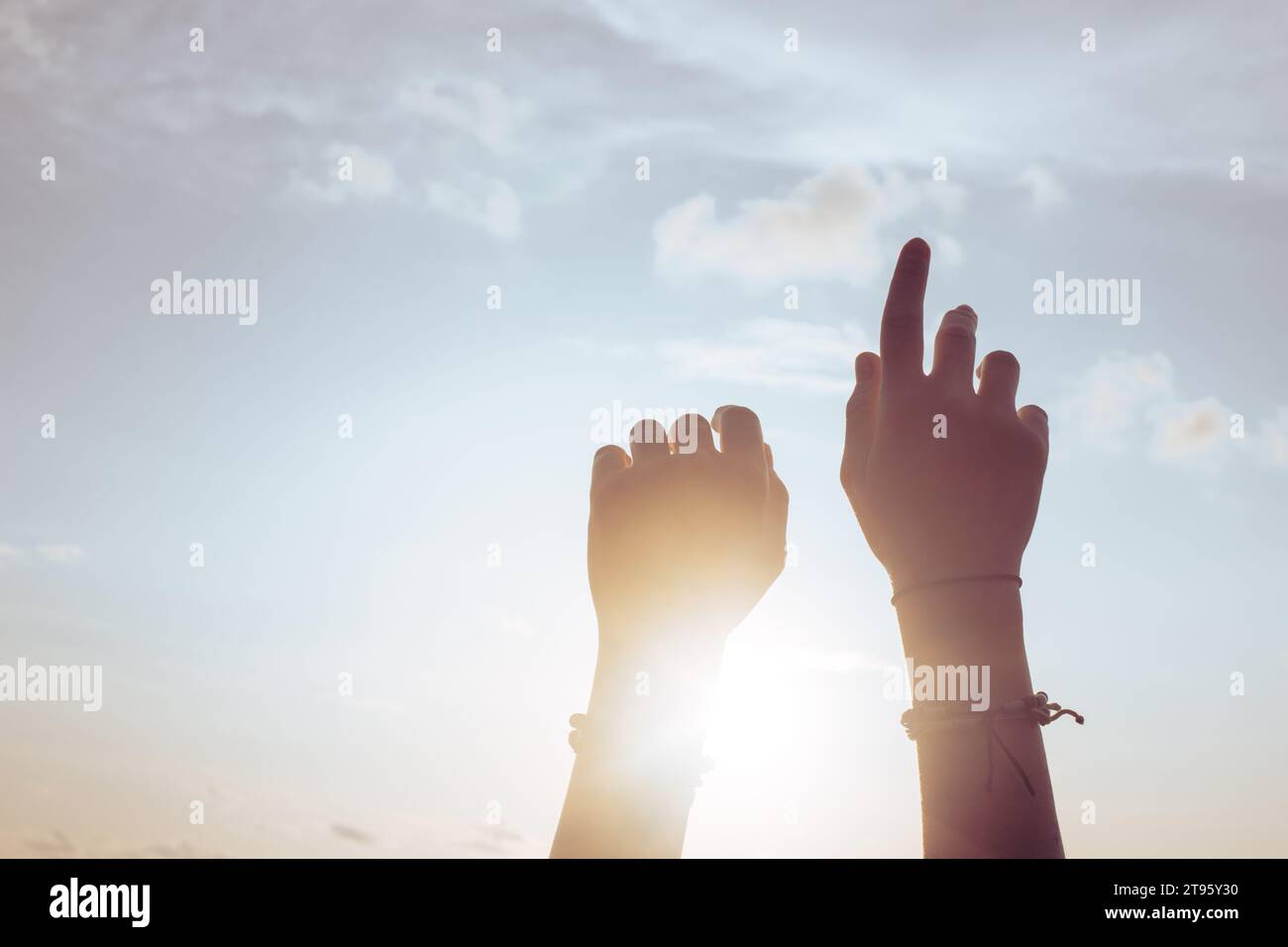 Le mani delle donne contro il cielo blu e il sole. Foto di alta qualità Foto Stock