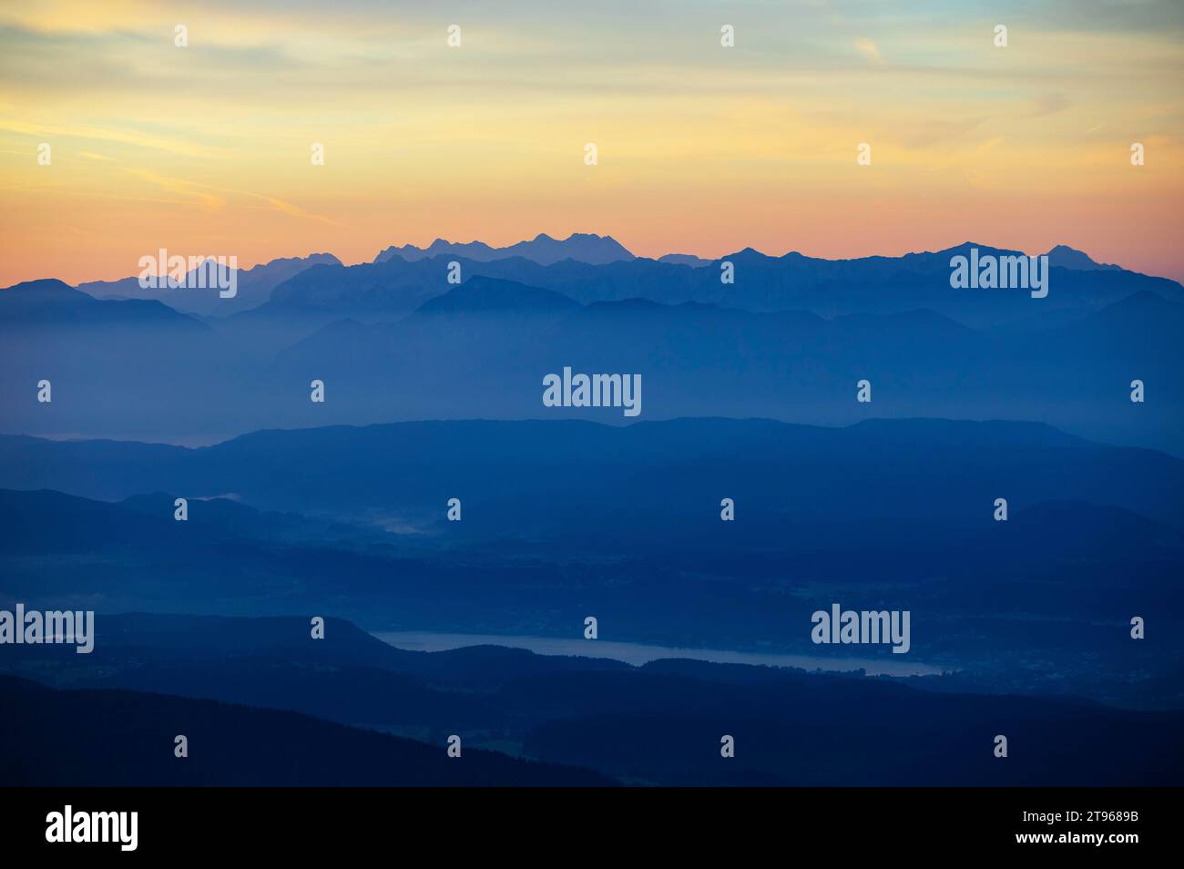 Profilo di montagna, montagne all'alba con vista sul bacino di Klagenfurt con il lago Woerth e Karawanken, Gerlitzen, l'Alpe di Gerlitzen Foto Stock