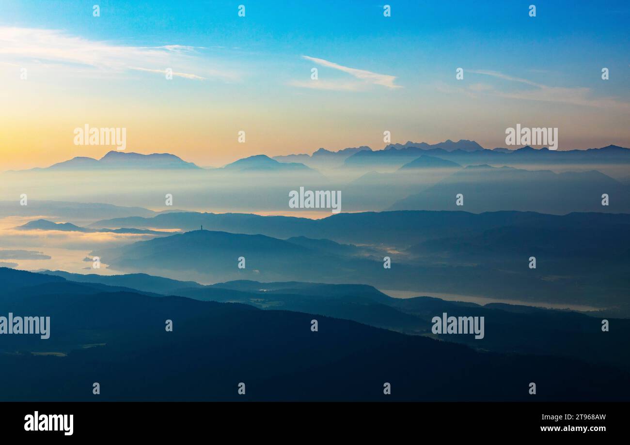 Profilo di montagna, montagne all'alba con vista sul bacino di Klagenfurt con il lago Woerth e Karawanken, Gerlitzen, l'Alpe di Gerlitzen Foto Stock