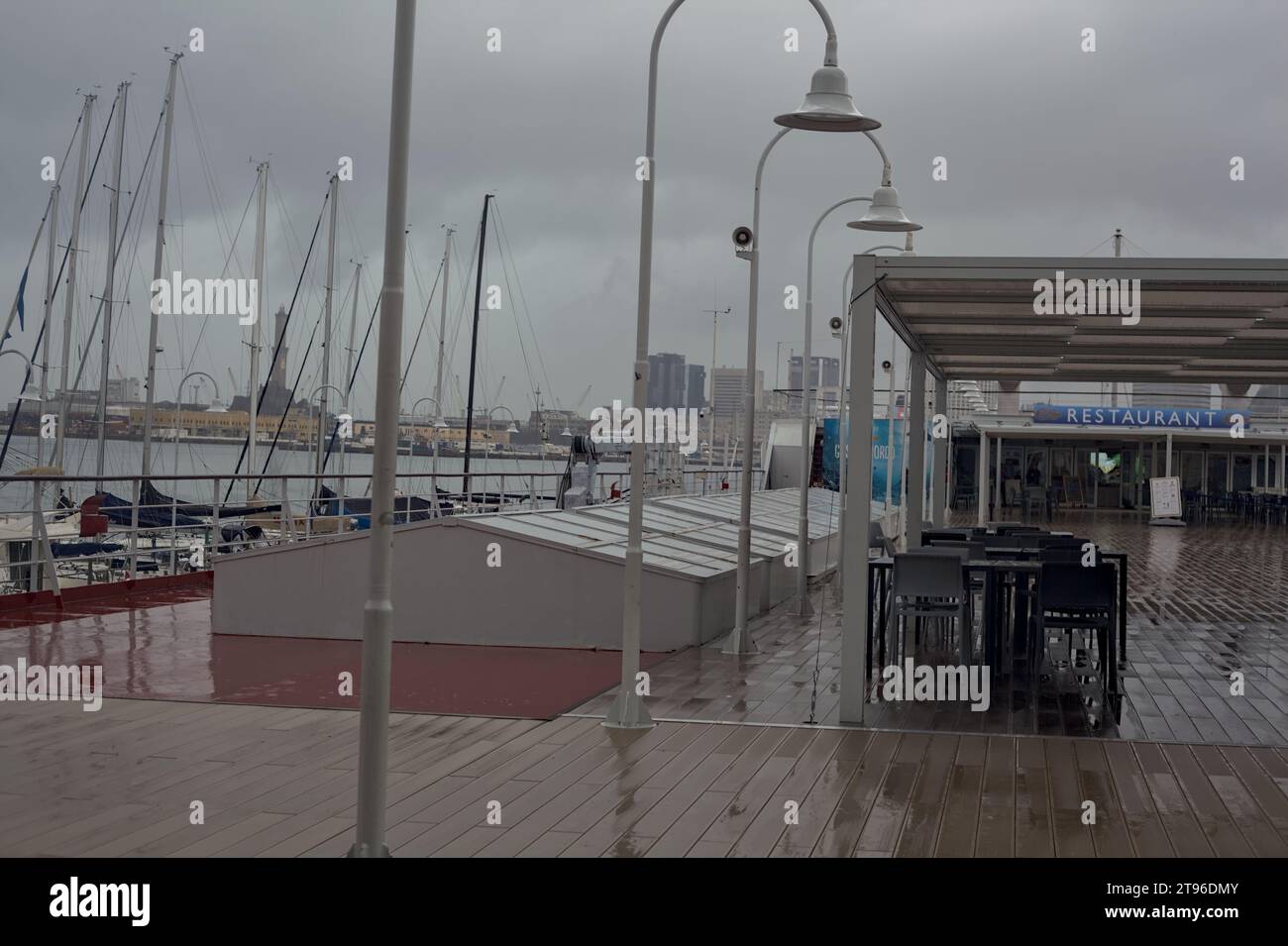 Genova, Italia - novembre 2023 - Porto visto dalla terrazza dell'Acquario di Genova e dalla Lanterna di Genova in lontananza in una giornata di pioggia Foto Stock