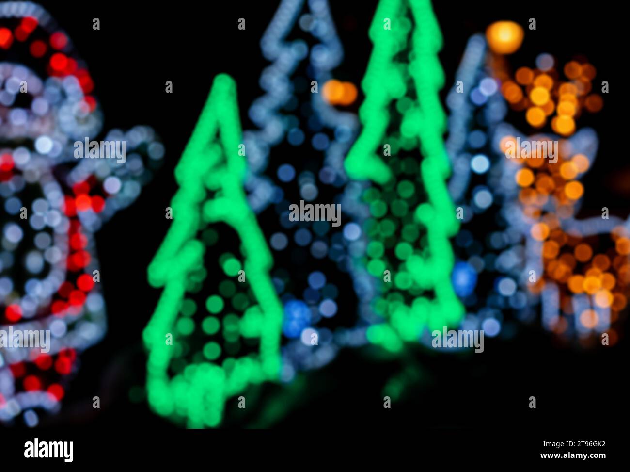 Decorazioni per le strade natalizie in stile bokeh. Ghirlande sfocate a forma di albero di Natale. Foto Stock