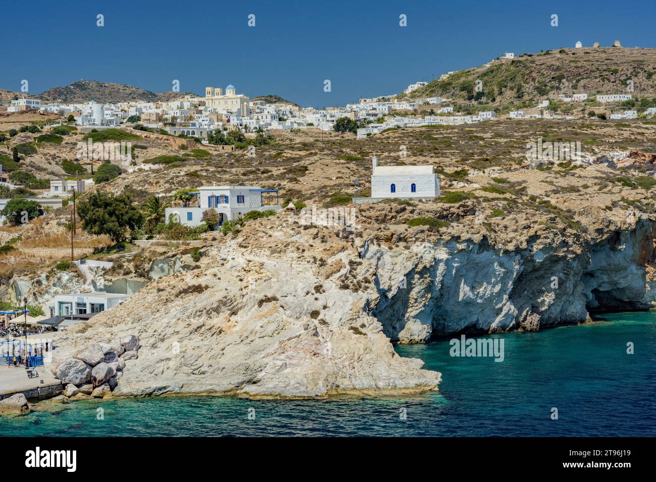 Vista costiera dell'isola di Kimolos con il villaggio di Chorio arroccato sulla collina Foto Stock