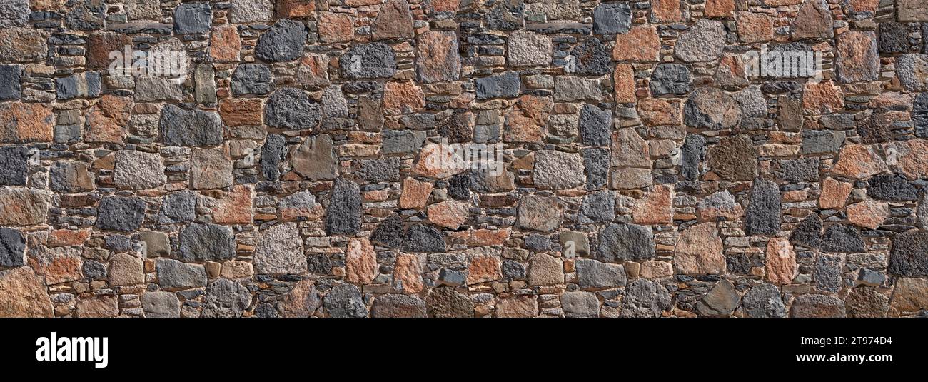 Parete in pietra realizzata in pietre naturali vulcaniche di colore blu, grigio e rosso con dimensioni diverse Foto Stock
