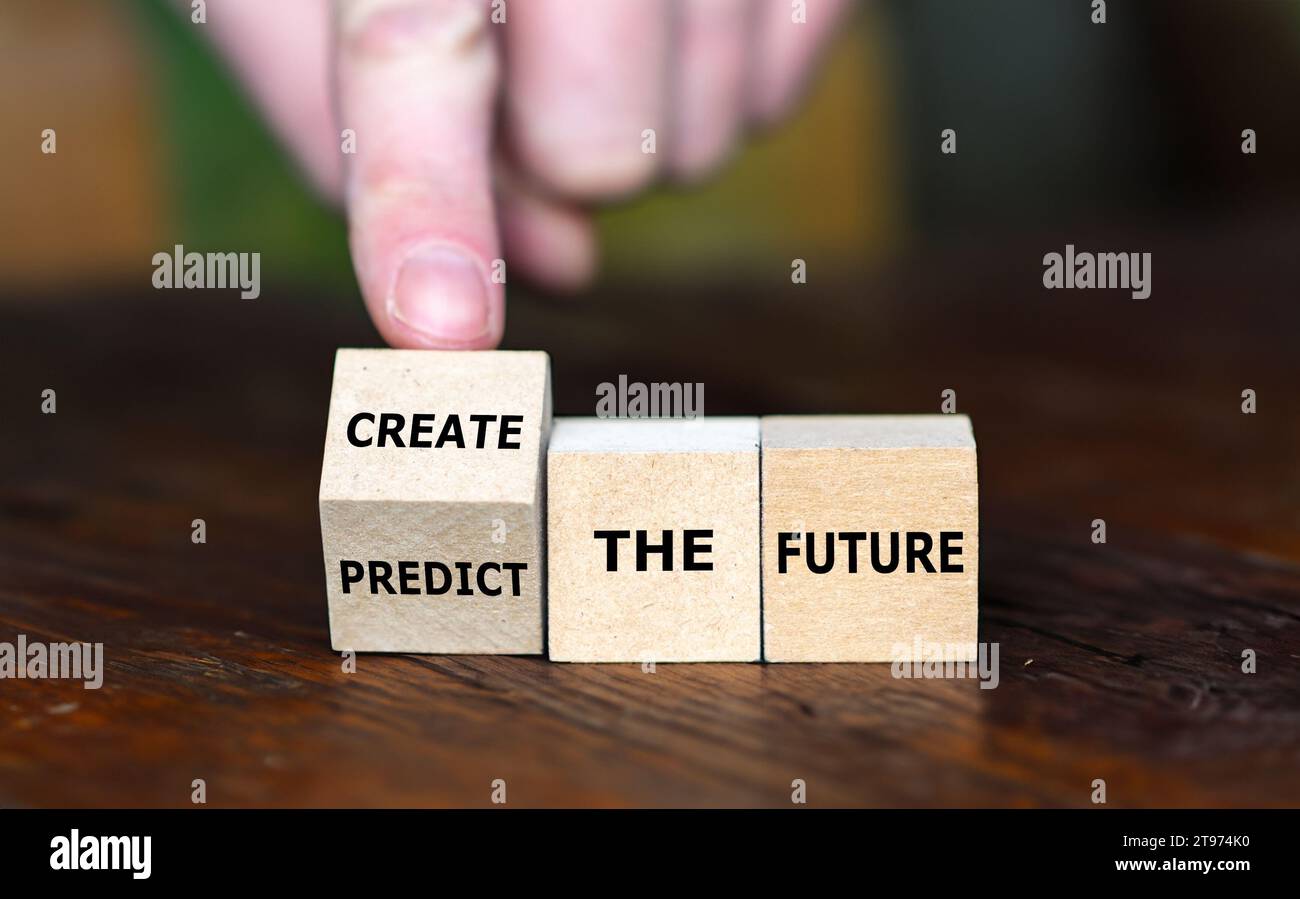 La mano ruota il cubo di legno e cambia l'espressione "prevedere il futuro" per "creare il futuro". Foto Stock