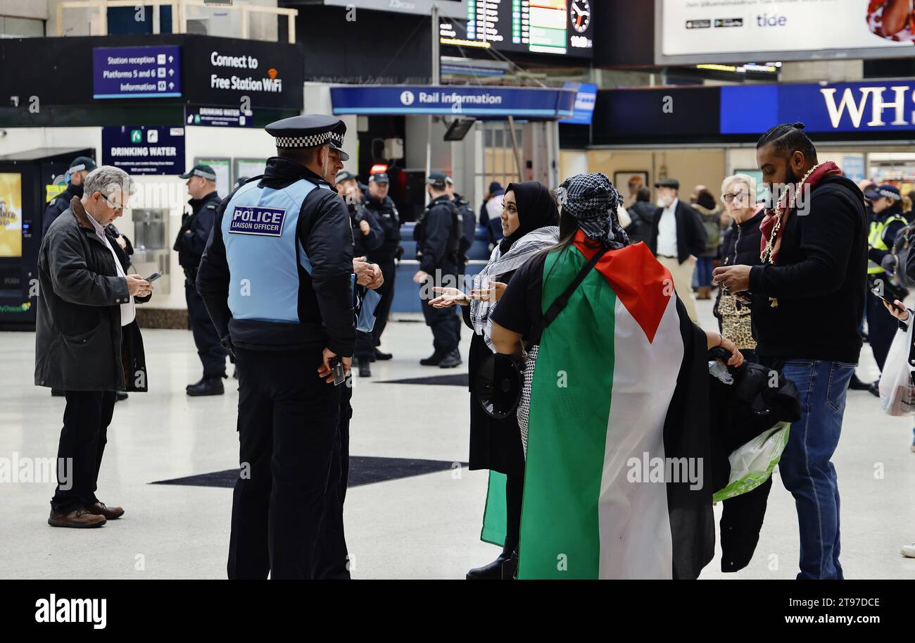 Inghilterra, Londra, Charring Cross Station, agenti di polizia di collegamento si impegnano con i sostenitori palestinesi e chiedono loro di rimuovere la bandiera palestinese, altrimenti potrebbero violare un reato di ordine pubblico. Foto Stock