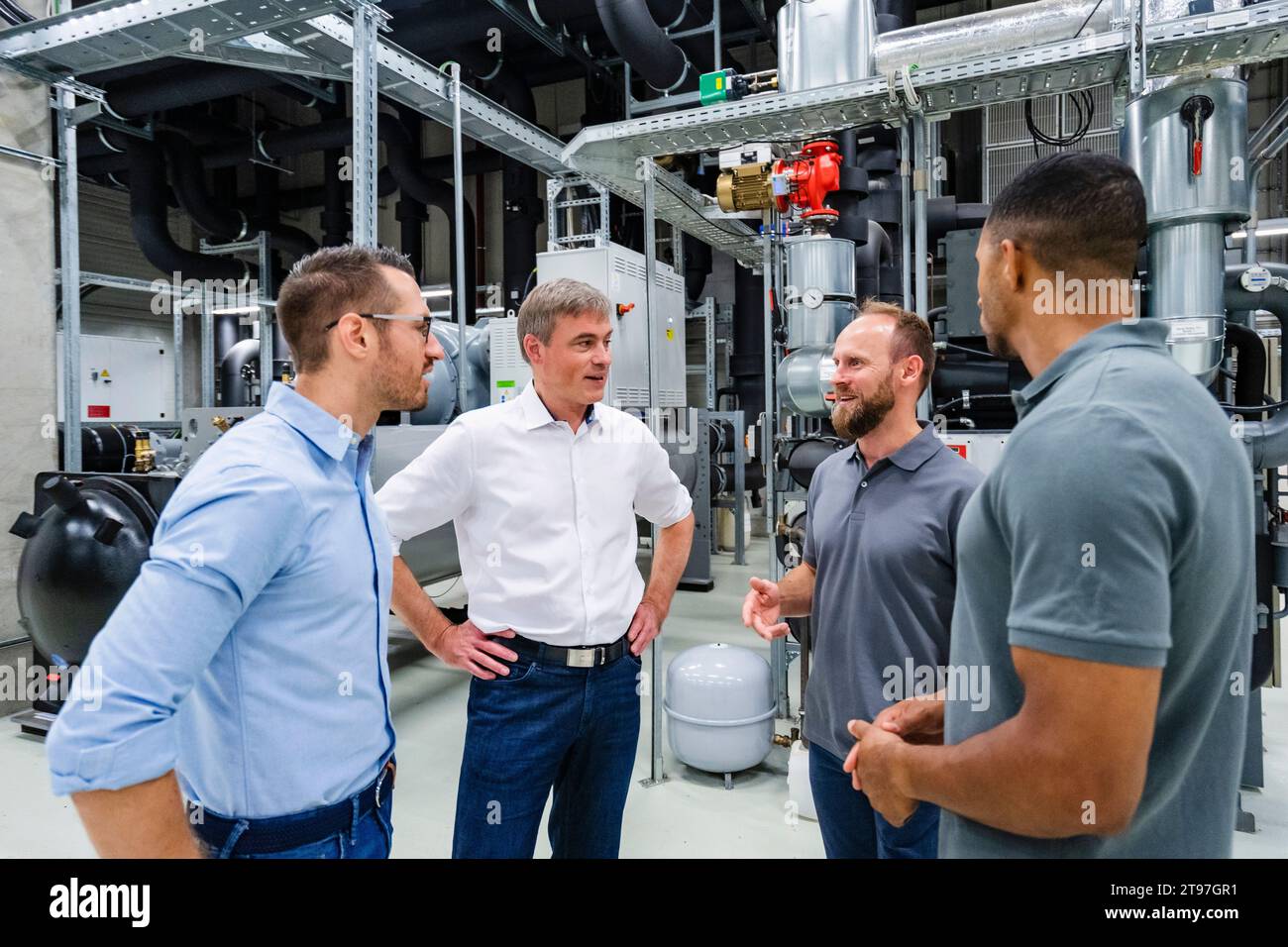 Uomini d'affari e impiegati che hanno una riunione in fabbrica Foto Stock