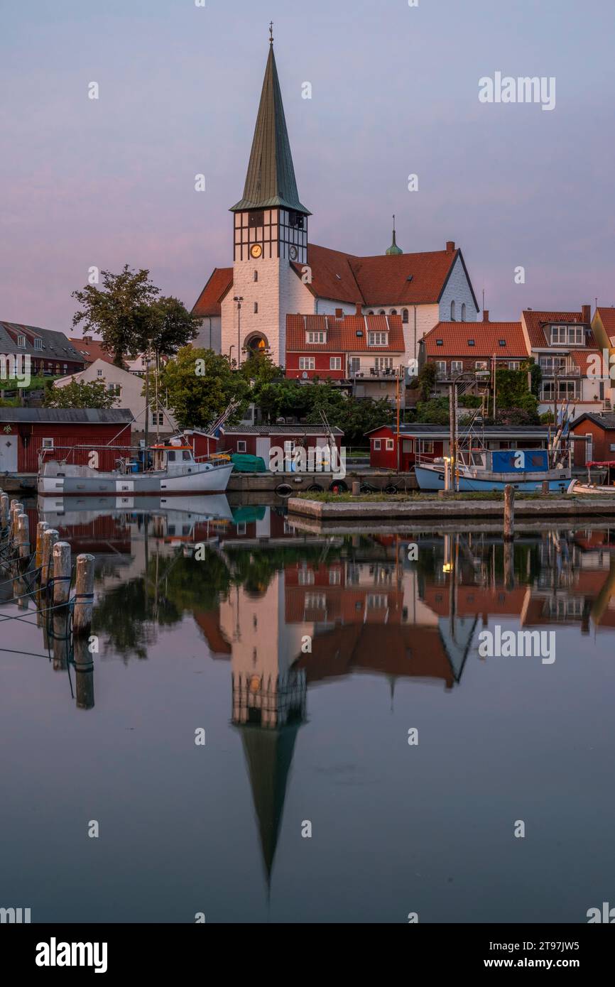 Danimarca, Bornholm, Ronne, Chiesa di San Nicola che si riflette nelle acque costiere al crepuscolo Foto Stock