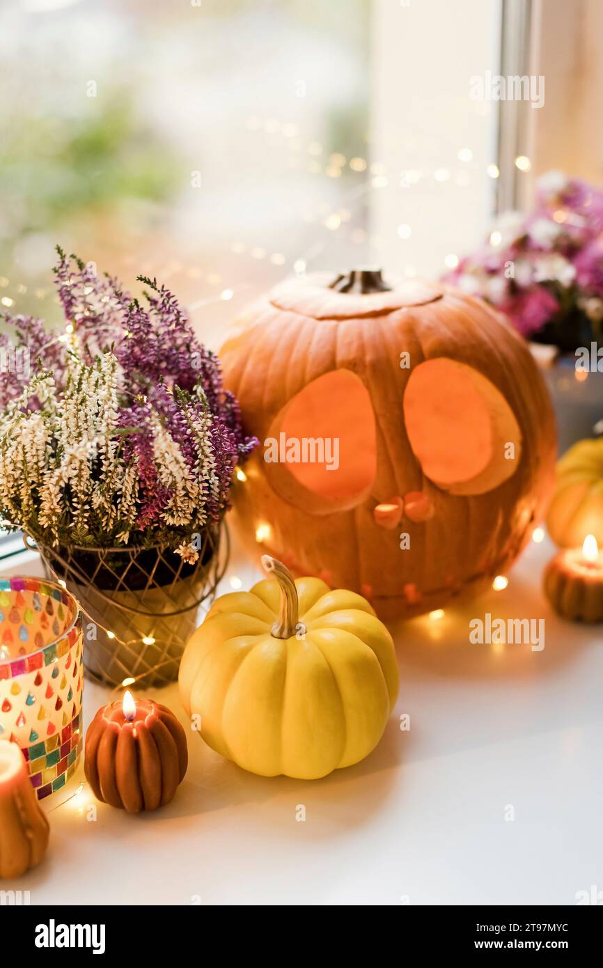 Decorazioni di Halloween con luci e zucche intagliate sul davanzale Foto Stock
