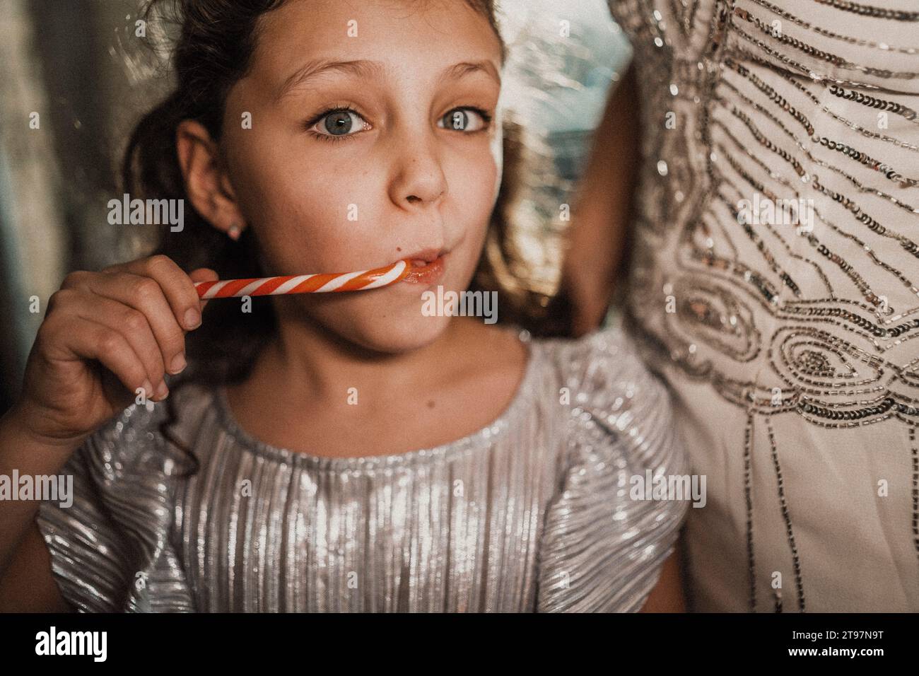 Ragazza che mangia canna da zucchero con la madre a casa Foto Stock