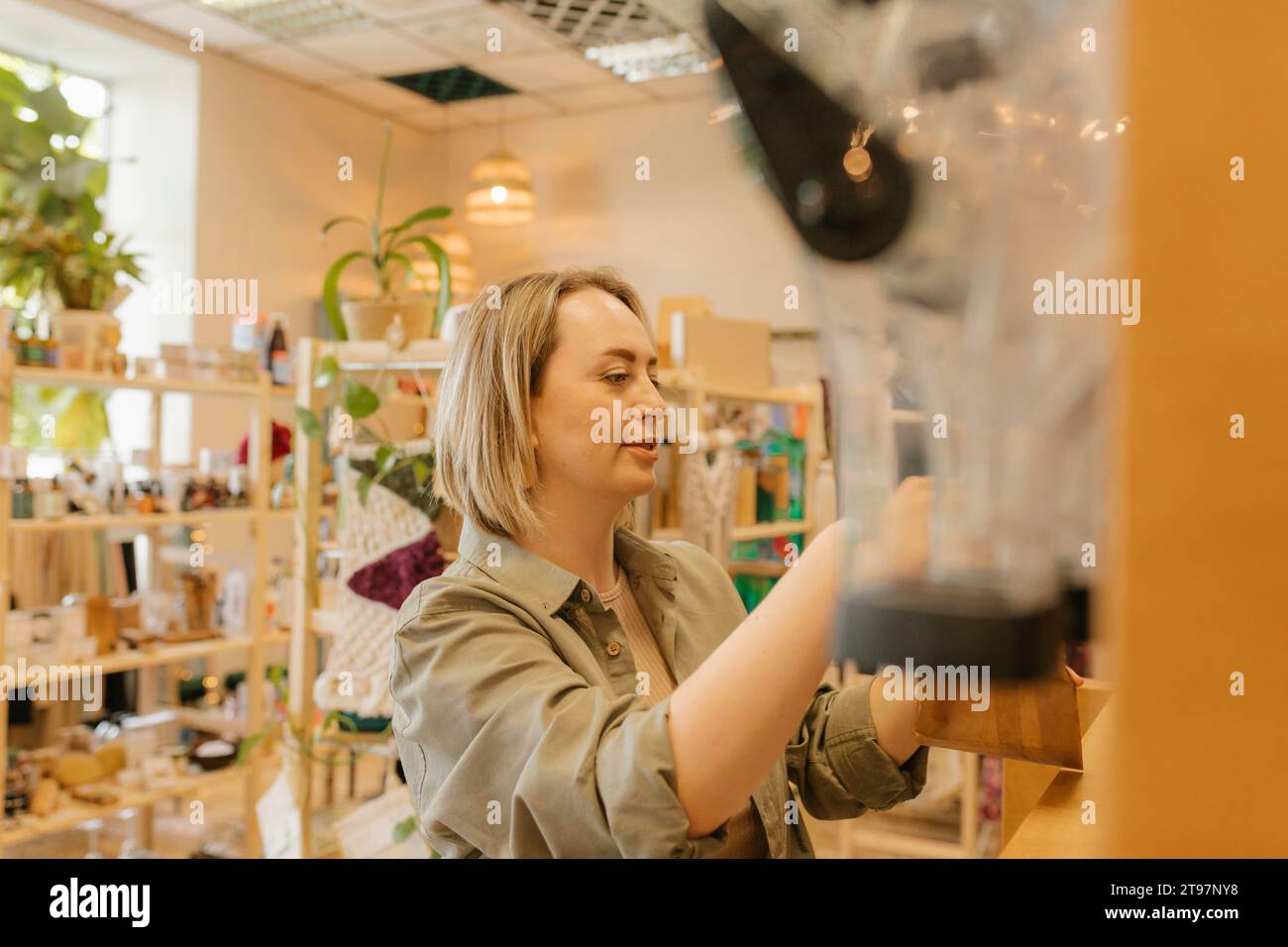 Donna bionda che fa shopping in un negozio biologico Foto Stock