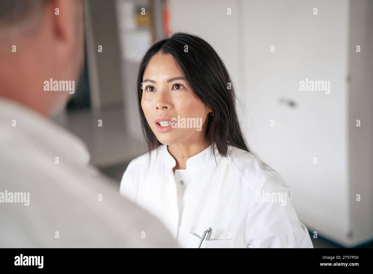 Scienziato che discute con un collega nel corridoio del laboratorio Foto Stock