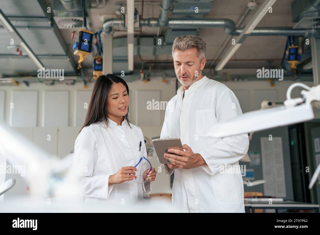 Scienziati che discutono su un tablet PC in laboratorio Foto Stock