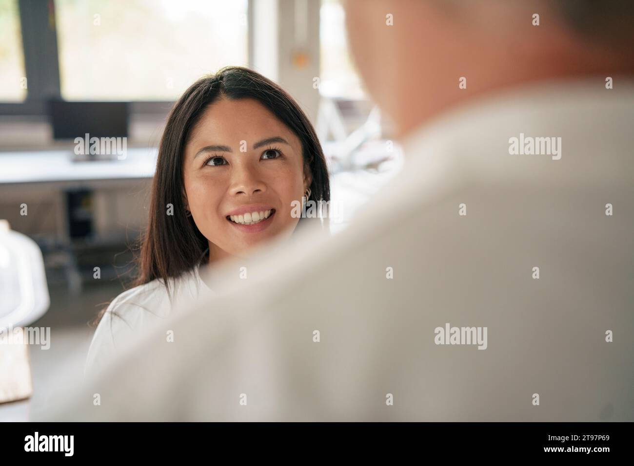 Felice scienziato che parla con un collega in laboratorio Foto Stock