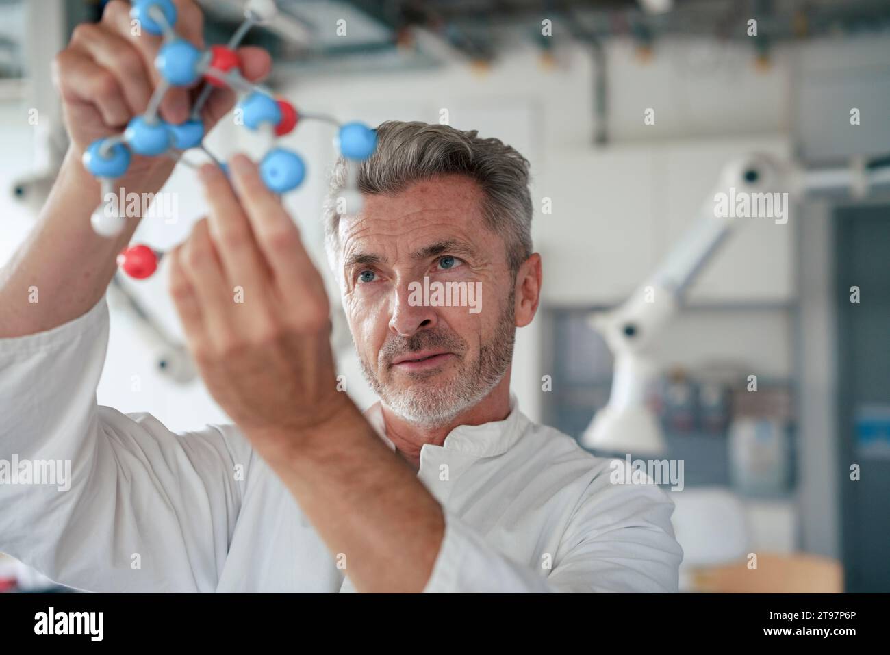 Scienziato maturo che esamina la struttura molecolare in laboratorio Foto Stock