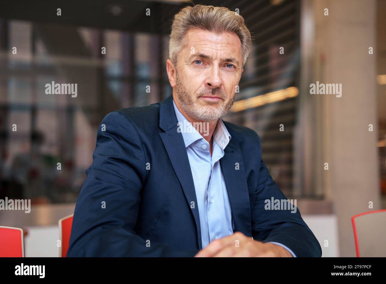 Uomo d'affari maturo seduto con un computer portatile in una caffetteria Foto Stock