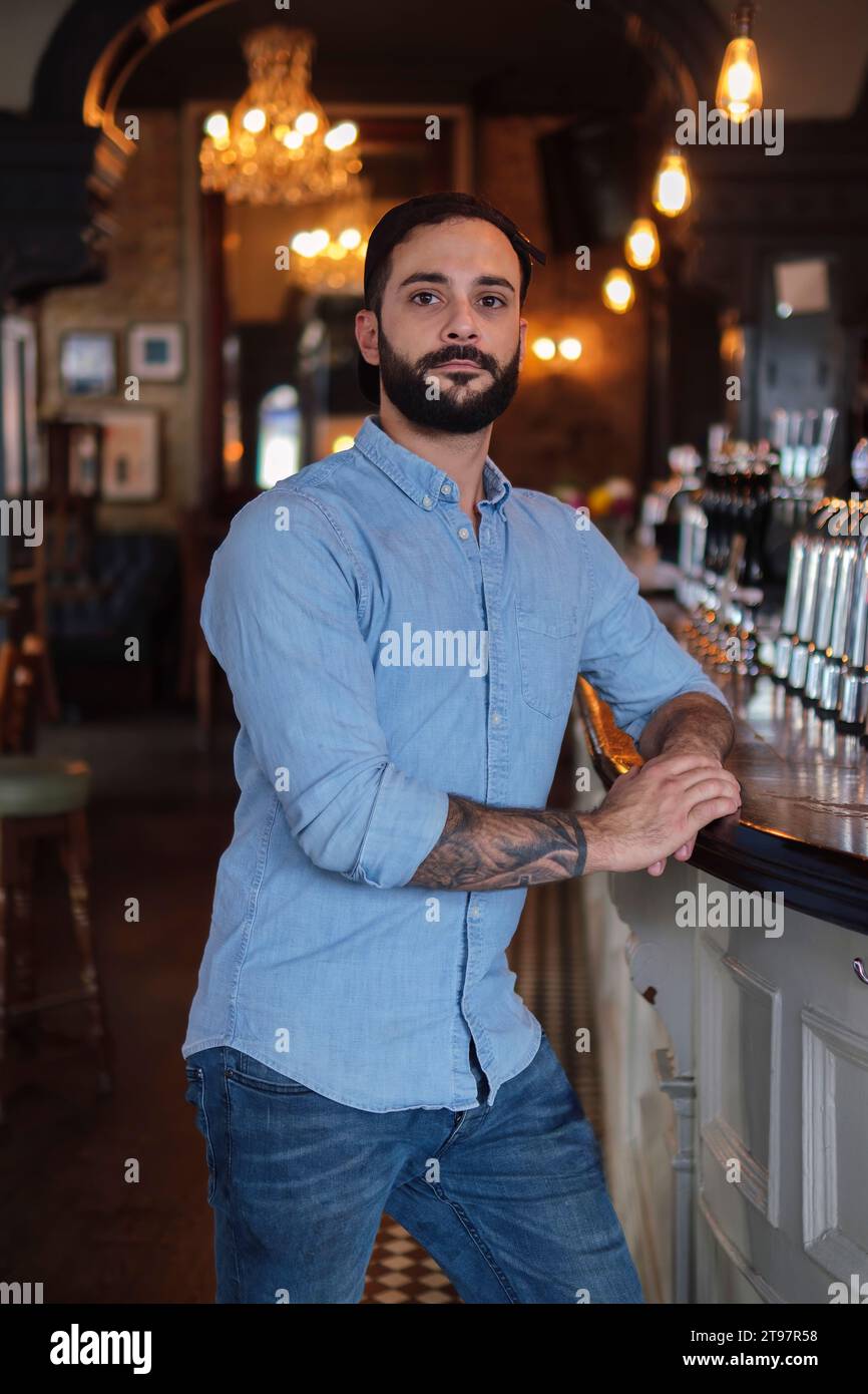 Il proprietario si trovava vicino al bancone del bar del pub Foto Stock