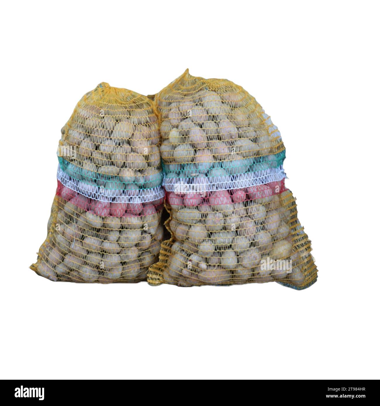 Un primo piano delle patate, esposto in due sacchetti e due sacchi in rete Foto Stock