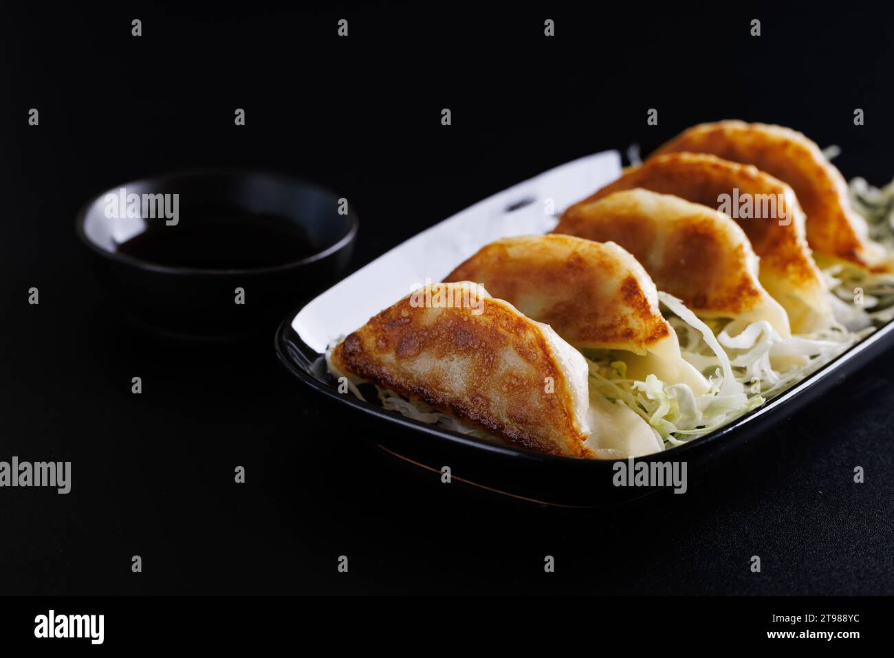 Gyoza cibo giapponese gnocco isolato su sfondo nero Foto Stock