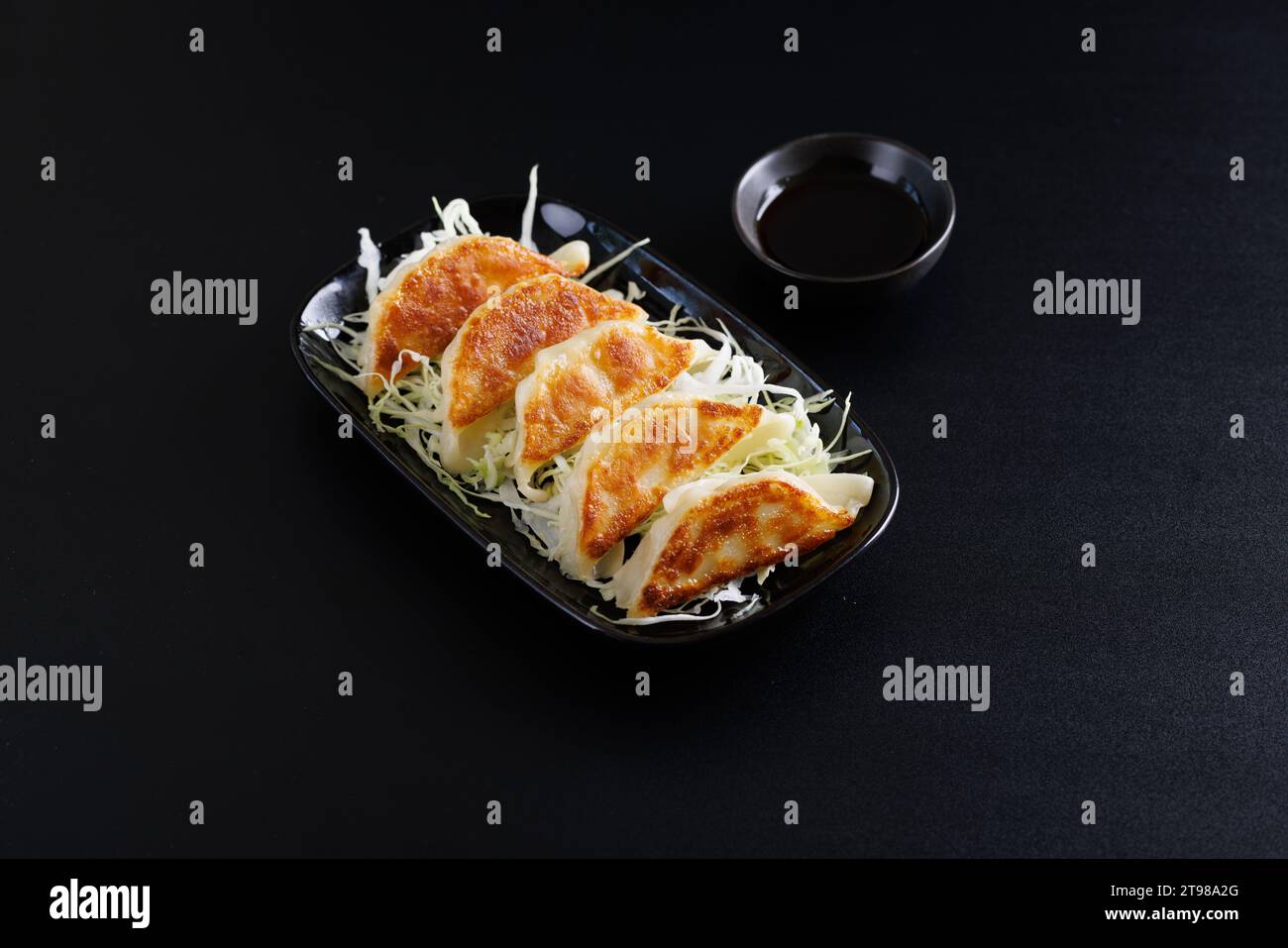 Gyoza cibo giapponese gnocco isolato su sfondo nero Foto Stock