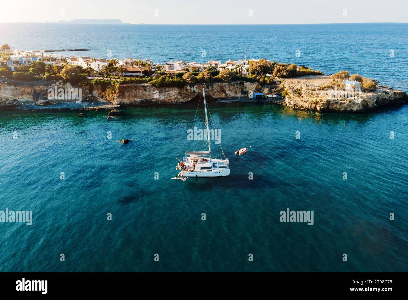 Vista droni del catamarano ancorato nel mare blu con persone che nuotano. Sfondo del viaggio. Vacanze in crociera. Foto Stock