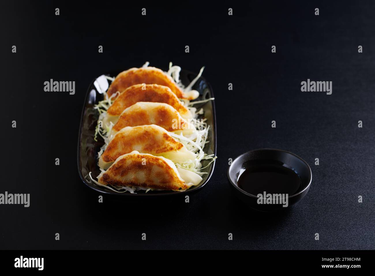 Gyoza cibo giapponese gnocco isolato su sfondo nero Foto Stock