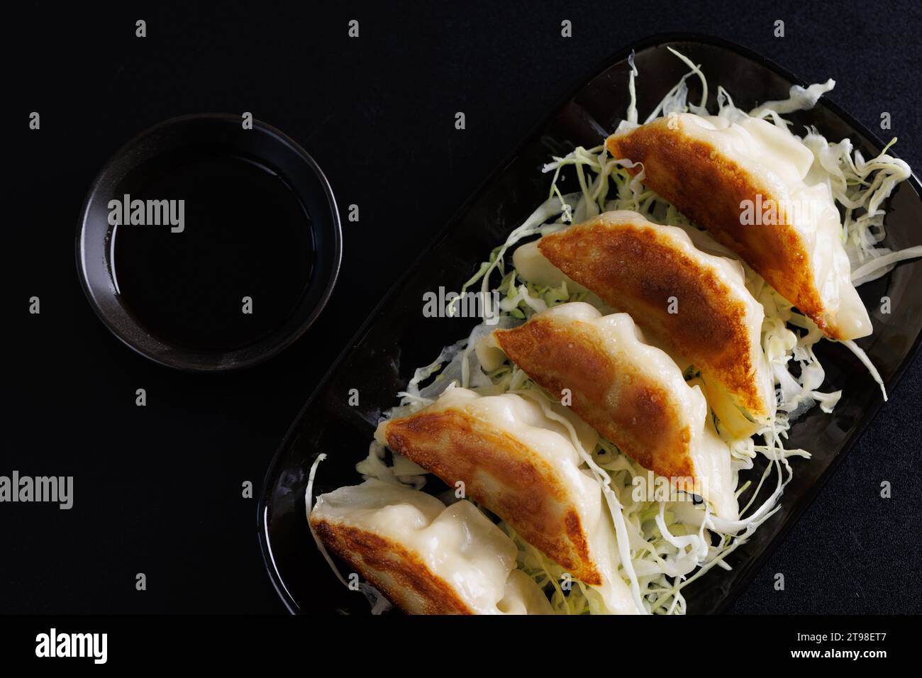 Gyoza cibo giapponese gnocco isolato su sfondo nero Foto Stock