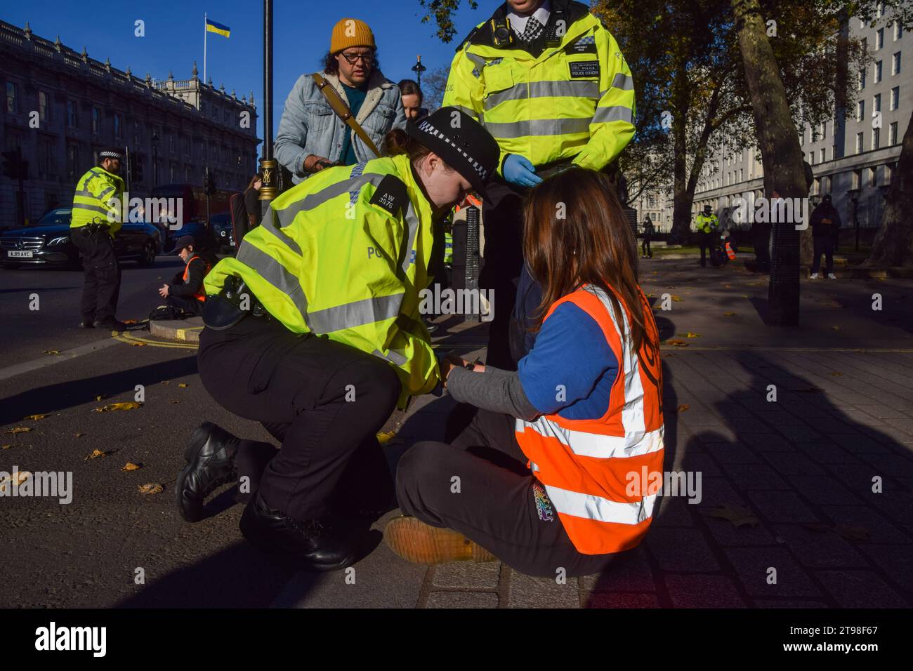 Londra, Regno Unito. 23 novembre 2023. Gli agenti della polizia metropolitana arrestano un attivista della Just Stop Oil durante la manifestazione a Whitehall, fuori Downing Street. Il gruppo di azione per il clima ha marciato da Trafalgar Square sul marciapiede e sono stati arrestati pochi secondi dopo essere saliti sulla strada il quarto giorno di fila mentre continuano le loro proteste contro le nuove licenze per i combustibili fossili. (Foto di Vuk Valcic/SOPA Images/Sipa USA) credito: SIPA USA/Alamy Live News Foto Stock