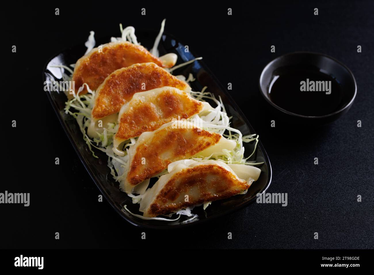 Gyoza cibo giapponese gnocco isolato su sfondo nero Foto Stock