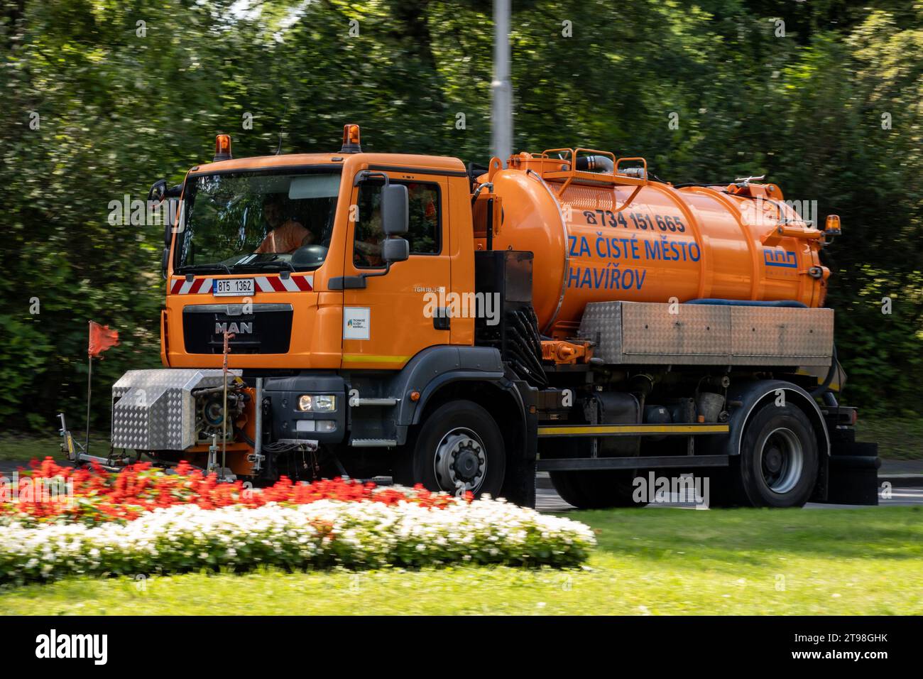 HAVIROV, REPUBBLICA CECA - 10 AGOSTO 2023: Camion per la pulizia arancione TGM 18,340 su una strada con effetto di sfocatura del movimento nelle strade di Havirov Foto Stock