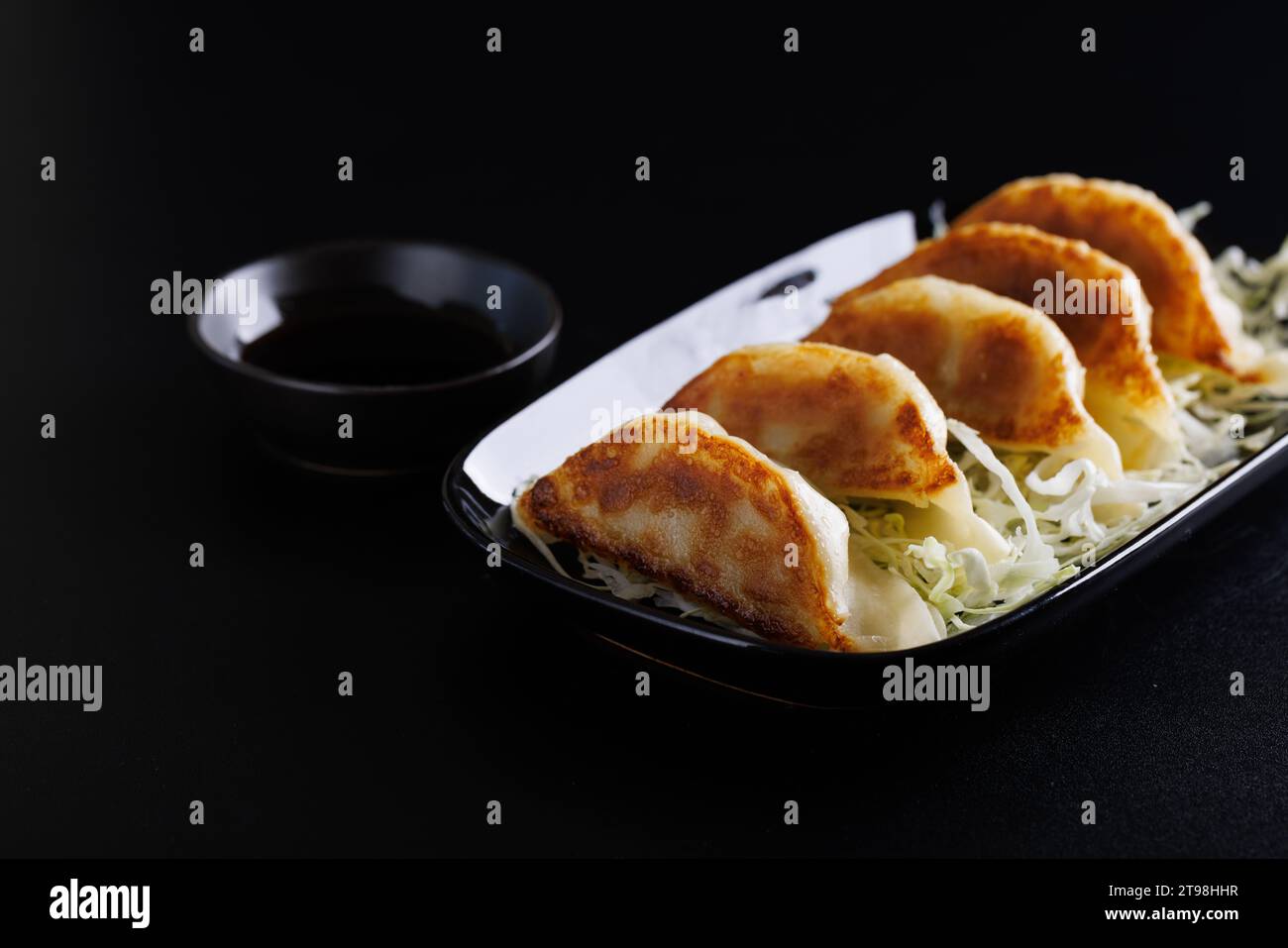 Gyoza cibo giapponese gnocco isolato su sfondo nero Foto Stock