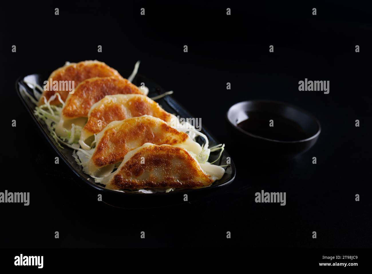 Gyoza cibo giapponese gnocco isolato su sfondo nero Foto Stock