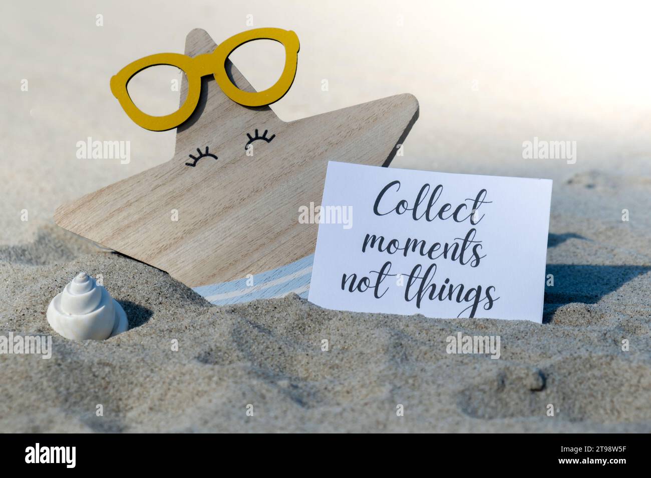 RACCOGLIERE MOMENTI NON COSE testo su carta biglietto di auguri sullo sfondo di divertente stella marina in occhiali decorazione vacanza estate. Spiaggia di sabbia costa sole. Rallentare, godersi il momento, momenti buoni, slow life concetto di vacanza cartolina. Un concetto di viaggio d'affari Foto Stock