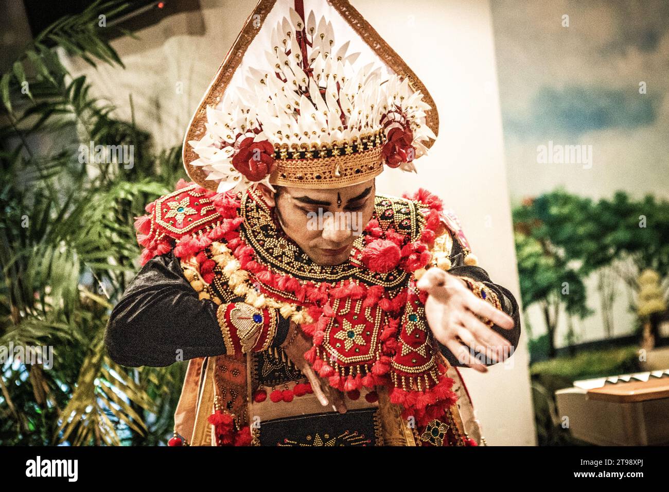 Un ballerino maschio balinese danzerà una danza tradizionale balinese indossando tradizionali abiti rossi balinesi in un caffè a Shanghai, in Cina Foto Stock