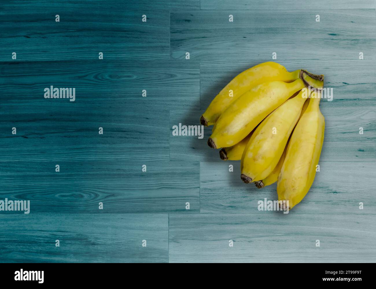 Banane mature su uno sfondo di legno turchese in Brasile Foto Stock