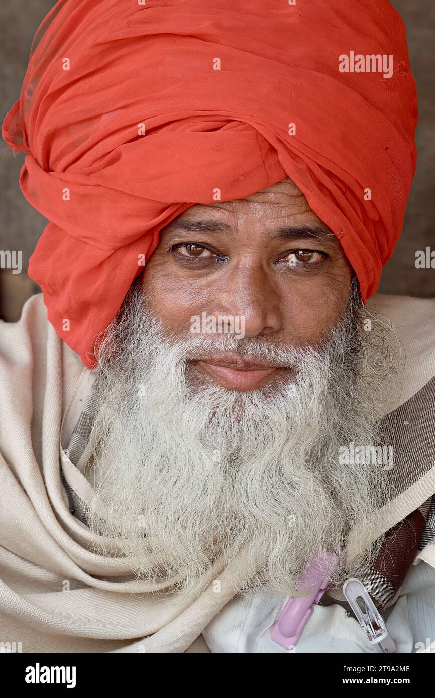 Un carismatico ascetico indù a Mumbai, in India, non vestito con il tradizionale abito Sadhu (uomo santo), ma con abiti, con uno scialle e un turbante rosso Foto Stock